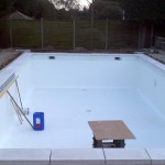 Tiled Band being laid around the top of swimming pool.